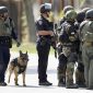 Police officers and a police dog prepare to search a suburban street during a manhunt in Sunnyvale, California, October 5, 2011.  A disgruntled worker, identified as Shareef Allman, opened fire on Wednesday at a Northern California cement plant and quarry, killing two people and injuring six, police said. Allman was also suspected of shooting a woman contract worker for Hewlett Packard during an attempted carjacking a short time later, Santa Clara County Sheriff's spokesman Sgt. Jose Cardoza said. REUTERS/Beck Diefenbach (UNITED STATES - Tags: CRIME LAW ANIMALS) - RTR2S9HP