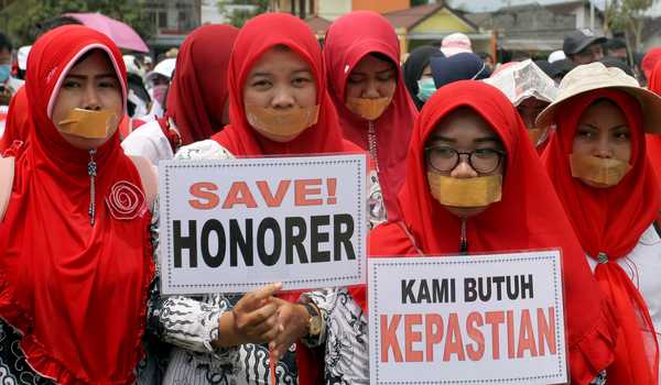 Guru honorer dan guru tidak tetap melakukan aksi tutup mulut saat menggelar aksi di halaman kantor Bupati Blitar, Jawa Timur, Senin (29/10/2018). Sejumlah guru honorer dan guru tidak tetap (GTT) yang tergabung dalam Persatuan Guru Republik Indonesia (PGRI) Blitar itu menuntut pemda setempat agar segera menerbitkan perda tentano GTT dan Honorer, serta meminta pemerintah segera mengangkat status mereka menjadi PNS. ANTARA FOTO/Irfan Anshori/kye.