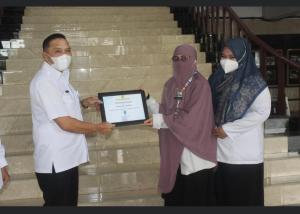 Plh Sekda Kota Banjarmasin menyerahkan penghargaan pelayanan publik tahun 2021 kepada 3 Puskesmas di Kota Banjarmasin
