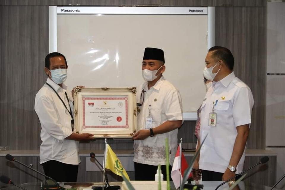 Penjabat Walikota Banjarmasin, Akhmad Fydayeen SH. M.Si didampingi Pelaksana Harian Sekretaris Daerah, Drs Mukhyar M.Ap menyerahkan penghargaan kepada sejumlah SKPD