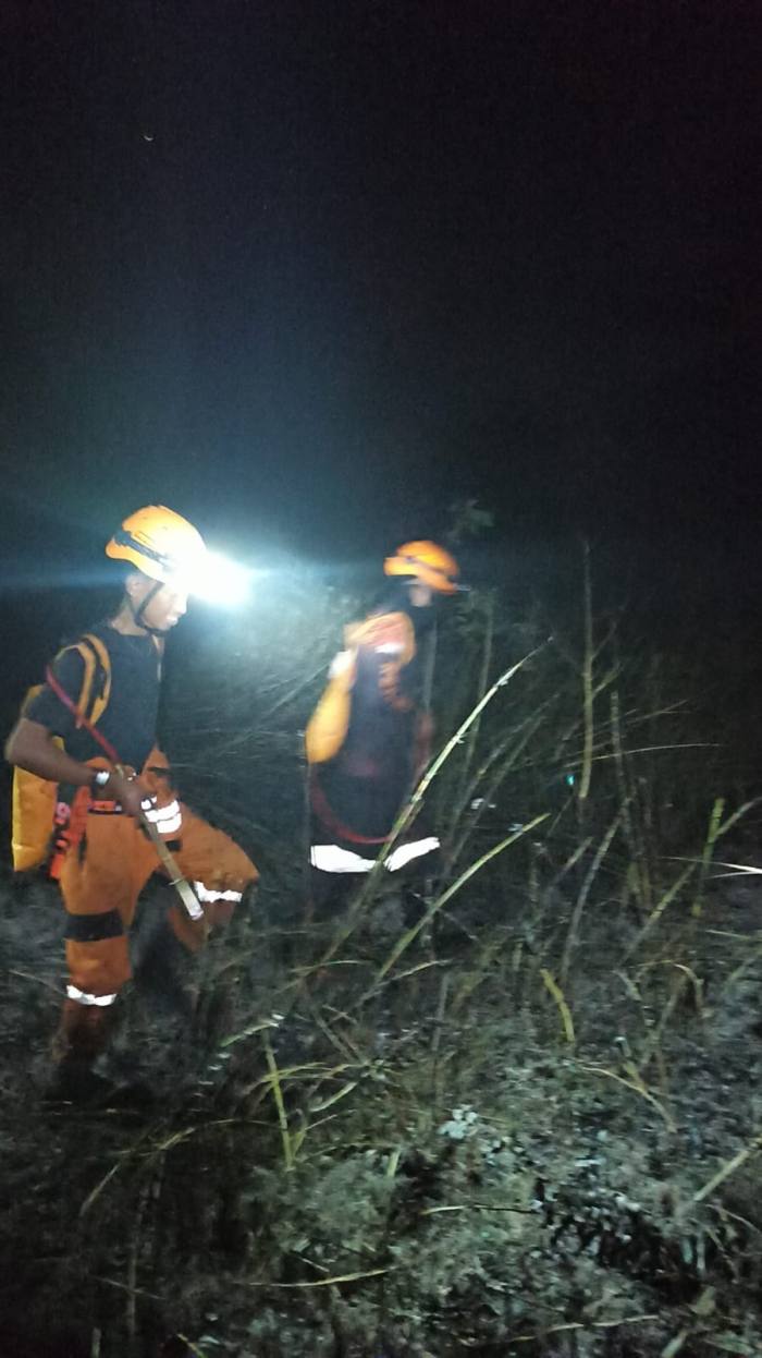 Personil dari BPBD Kalsel bersama berbagai komponen bergerak ekstra Siaga-  melakukan pemadaman kebakaran lahan hingga malam hari. Foto Ist