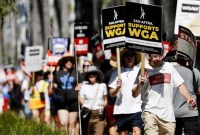 Anggota Screen Actors Guild berjalan di garis piket dalam solidaritas dengan anggota Writers Guild of America yang mogok di luar kantor Netflix di Los Angeles, Kamis (13/7/2023) waktu setempat. (Foto: Mario Tama/Getty Images)