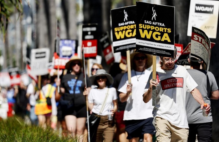 Anggota Screen Actors Guild berjalan di garis piket dalam solidaritas dengan anggota Writers Guild of America yang mogok di luar kantor Netflix di Los Angeles, Kamis (13/7/2023) waktu setempat. (Foto: Mario Tama/Getty Images)