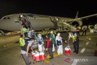 Petugas membantu jamaah haji kelompok terbang (kloter) pertama embarkasi Banjarmasin saat tiba di Bandara Internasional Syamsudin Noor, Banjarbaru, Kalimantan Selatan, Senin (10/7/2023). Foto ANTARA/Bayu Pratama S.
