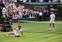 Petenis Spanyol, Carlos Alcaraz (kiri), merayakan kemenangannya atas Novak Djokovic dari Serbia pada final tunggal putra Wimbledon 2023 di The All England Tennis Club, London, Inggris, Minggu (16/7/2023). (Foto: AFP PHOTO)