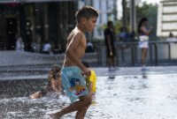 Anak-anak menyejukkan diri di air mancur umum di Milan, Italia, Sabtu, 15 Juli 2023. Suhu mencapai hingga 42 derajat Celcius di beberapa bagian negara itu, di tengah gelombang panas yang terus melanda Eropa selatan. (Foto: AP/Luca Bruno)