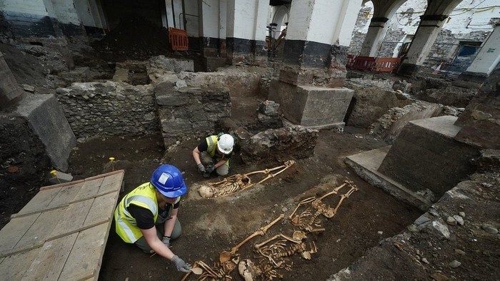 Seorang anggota tim arkeologi memeriksa sisa-sisa kerangka yang ditemukan selama pekerjaan persiapan untuk sebuah hotel baru di Kota Dublin. (Foto: PA Media)