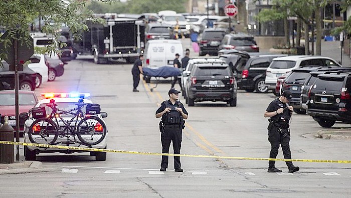 Petugas penyelamat membawa korban setelah tembakan meletus di rute Parade Hari Kemerdekaan Amerika Serikat di Highland Park, pinggiran Chicago, Illinois, Amerika Serikat, Senin (4/7/2022). Sebanyak 6 orang dilaporkan tewas akibat penembakan tersebut. (Photo: Getty Images/Jim Vondruska)