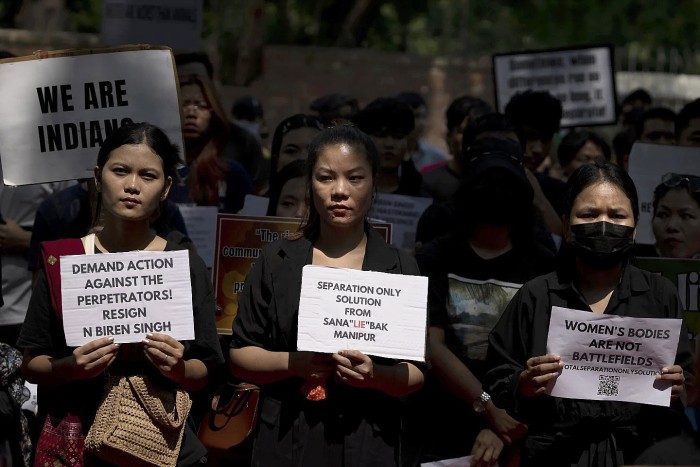 Para demonstran di India menuntut mundurnya pejabat tinggi Manipur, yang menjadi lokasi dua wanita diarak bugil dan diperkosa massal saat konflik antaretnis marak pada awal Mei lalu. (AP Photo/Altaf Qadri)
