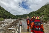 Petugas penyelamat berkumpul pada hari Sabtu (12/8/2023) setelah tanah longsor di desa Weiziping di kotapraja Luanzhen di pinggiran distrik Chang'an, Xi'an di Provinsi Shaanxi, China barat laut. (Foto: AP Photo)