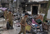 Petugas polisi berjalan melalui puing-puing rumah yang dirusak oleh massa Muslim yang marah di sebuah daerah Kristen di Jaranwala di distrik Faisalabad, Pakistan, Kamis (17/8/2023). (AP PHOTO)