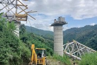 Petugas penyelamat melakukan operasi pencarian di lokasi kecelakaan di mana jembatan kereta api yang sedang dibangun runtuh di kota Sairang, distrik Aizwal di negara bagian Mizoram, India timur, Rabu (23/8/2023). (AFP Photo)