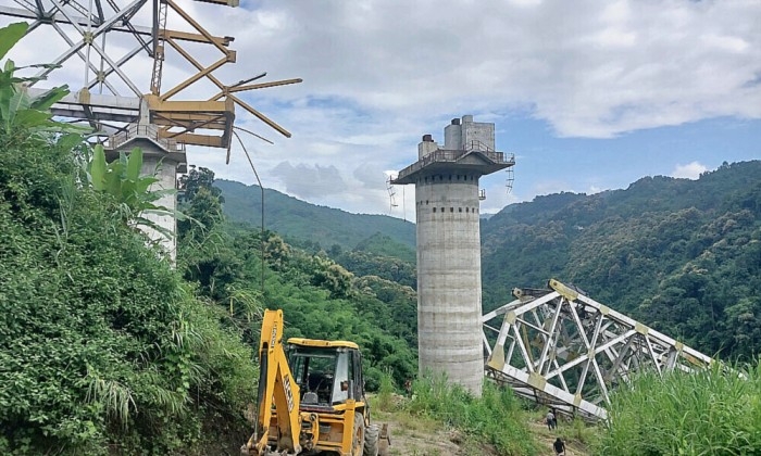Petugas penyelamat melakukan operasi pencarian di lokasi kecelakaan di mana jembatan kereta api yang sedang dibangun runtuh di kota Sairang, distrik Aizwal di negara bagian Mizoram, India timur, Rabu (23/8/2023). (AFP Photo)
