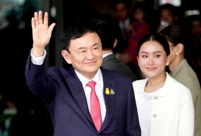 Thaksin Shinawatra bersama putrinya Paetongtarn Shinawatra saat dia tiba di Bangkok. (Wason Wanichakorn/AP)