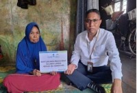 Sekretaris UPZ Bank Kalsel, Junaidi memyerahkan bantuan kepada Ibu Norhayati di tempat kediaman Jl Tatah Pelatar.