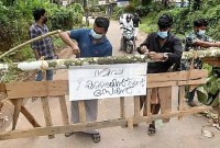 WARGA memasang tanda bertuliskan 'Zona penahanan Nipah' di barikade, yang dipasang untuk memblokir jalan setelah pihak berwenang menyatakan daerah itu sebagai zona penahanan, untuk mencegah penyebaran virus Nipah di desa Ayanchery di distrik Kozhikode, Kerala, India, Rabu (13/9/2023). (REUTERS/Stringer)