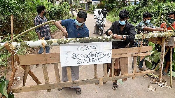 WARGA memasang tanda bertuliskan 'Zona penahanan Nipah' di barikade, yang dipasang untuk memblokir jalan setelah pihak berwenang menyatakan daerah itu sebagai zona penahanan, untuk mencegah penyebaran virus Nipah di desa Ayanchery di distrik Kozhikode, Kerala, India, Rabu (13/9/2023). (REUTERS/Stringer)