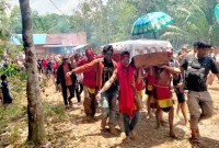 Warga Desa Bangkal, Kabupaten Seruyan, Kalteng, membawa jenazah Gijik salah satu korban dalam bentrok antarwarga dan aparat untuk dimakamkan. (BBC Indonesia/James Watt)