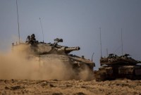 SEBUAH Pengangkut Personil Lapis Baja (APC) Israel tersembunyi saat menimbulkan debu di dekat perbatasan Israel dengan Jalur Gaza, di Israel selatan, Minggu (15/10/2023). Militer Israel menunggu keputusan politik sebagai 'lampu hijau' sebelum mereka melancarkan serangan besar-besaran ke Jalur Gaza.(REUTERS)
