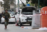 Seorang tentara Israel berjaga di samping truk pickup yang dilengkapi senapan mesin di kota selatan Sderot pada Sabtu (7/10/2023), setelah kelompok teror Palestina Hamas melancarkan serangan mendadak skala besar ke Israel. (Oren ZIV/AFP)
