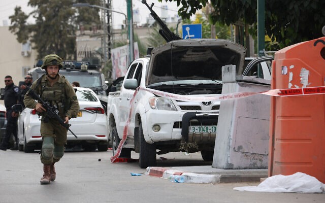 Seorang tentara Israel berjaga di samping truk pickup yang dilengkapi senapan mesin di kota selatan Sderot pada Sabtu (7/10/2023), setelah kelompok teror Palestina Hamas melancarkan serangan mendadak skala besar ke Israel. (Oren ZIV/AFP)