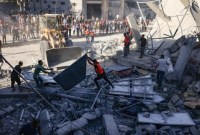 TIM penyelamat menyaring puing-puing bangunan yang runtuh menyusul serangan udara Israel di Rafah di Jalur Gaza selatan, Kamis (26/10/2023). (AFP/Said Khatib)