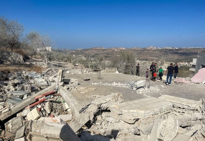 WARGA Palestina berdiri di atas reruntuhan setelah pasukan Israel menghancurkan rumah Saleh al-Arouri, dekat Ramallah di Tepi Barat yang diduduki Israel, Selasa (31/10/2023). (REUTERS/Ismael Khader)