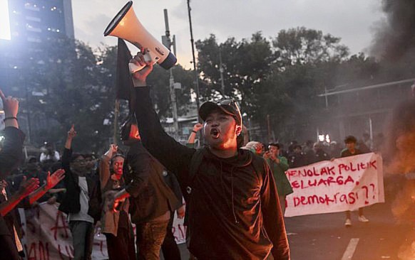 Sejumlah mahasiswa dari massa aksi evaluasi 9 tahun kepemimpinan Presiden Jokowi membakar ban hingga merobohkan barikade beton di depan Patung Kuda, Jakarta Pusat, Jumat (20/10/2023). (CNN Indonesia)