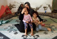 Wanita Palestina Samah Abu Latifa, yang meninggalkan rumahnya di tengah serangan Israel, berlindung bersama keluarganya di taman kanak-kanak, di khan Younis di selatan Jalur Gaza, Selasa (10/10/2023). (REUTERS/Ibraheem Abu Mustafa)