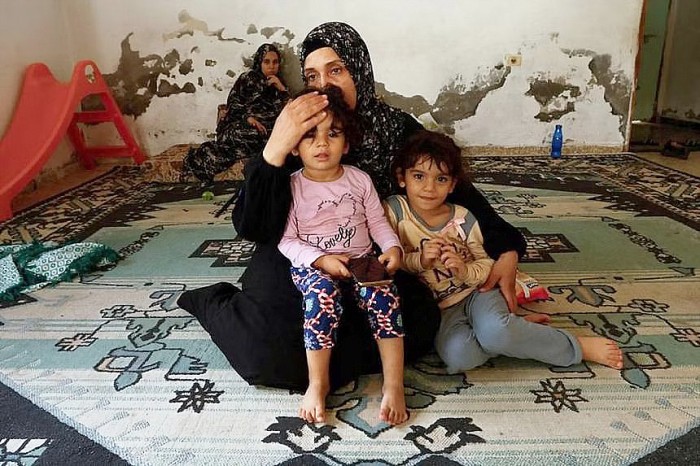 Wanita Palestina Samah Abu Latifa, yang meninggalkan rumahnya di tengah serangan Israel, berlindung bersama keluarganya di taman kanak-kanak, di khan Younis di selatan Jalur Gaza, Selasa (10/10/2023). (REUTERS/Ibraheem Abu Mustafa)