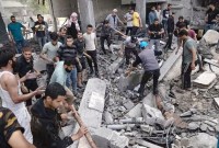 Warga Palestina mencari korban selamat di sebuah bangunan yang hancur akibat pemboman Israel di kamp pengungsi Rafah di Jalur Gaza, Selasa (17/10/2023). (AP Photo/Fatima Shbair)