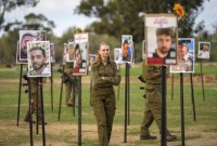 Ilustrasi. Seorang tentara wanita Israel melihat foto orang-orang yang terbunuh dan ditawan oleh militan Hamas, Kamis (28/11/2023). (AP/Ohad Zwigenberg)