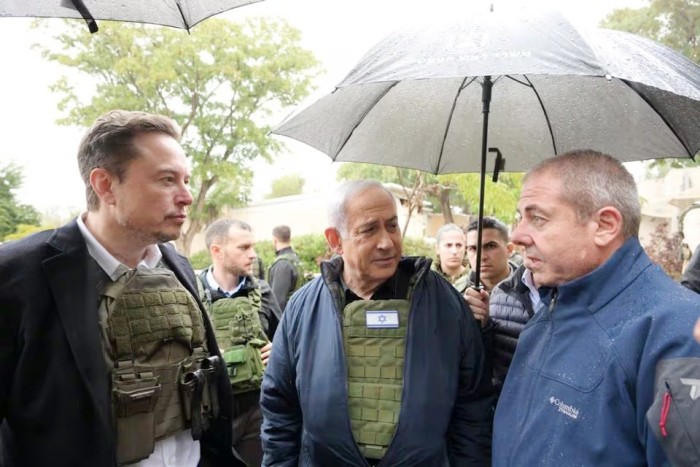 Perdana Menteri Israel Benjamin Netanyahu (tengah) mengajak Elon Musk (kiri) berkeliling Kibbutz Kfar Aza setelah pembantaian 7 Oktober terjadi di sana, di Kfar Aza, Israel, Senin (27/11/2023). (HANDOUT/GETTY)