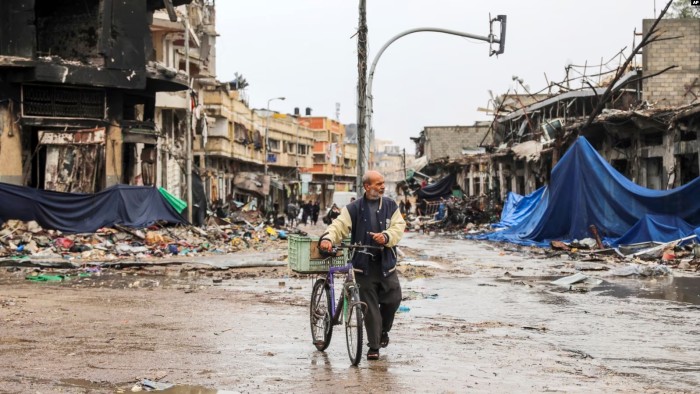 Seorang pria Palestina berjalan di Kota Gaza pada Senin, 27 November 2023 pada hari keempat gencatan senjata sementara antara Hamas dan Israel. (AP Photo)
