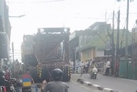Sebuah truk nomor polisi L 8892 UV bermuatan alat berat tersangkut di tanjakan sebuah jembatan Pekapuran arah Jalan Kolonel Sugiono, Senin (11/12/2023) (SuarIndonesia/ZI)