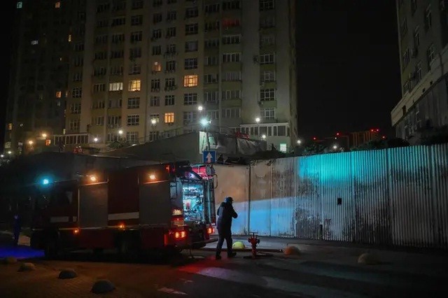 Tim penyelamat Ukraina bekerja di sebuah bangunan tempat tinggal bertingkat yang rusak di Kyiv, Jumat (22/12/2023), terkena serangan drone Rusia pada akhir Kamis (21/12/2023), di tengah invasi Rusia ke Ukraina. Setidaknya dua orang terluka, pihak berwenang mengumumkan. [Foto: AFP/Sergei SUPINSKY]
