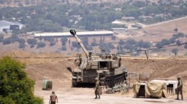 Tentara Israel berdiri di dekat kendaraan artileri self-propelled di pinggiran Kiryat Shmona dekat perbatasan Israel dengan Lebanon. [AFP/Jalaa Marey]