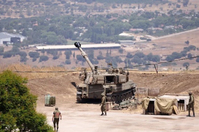 Tentara Israel berdiri di dekat kendaraan artileri self-propelled di pinggiran Kiryat Shmona dekat perbatasan Israel dengan Lebanon. [AFP/Jalaa Marey]