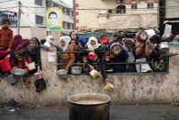 Warga Palestina mengantri untuk mendapatkan makanan gratis di Rafah, Jalur Gaza, Kamis (21/12/2023). Badan bantuan internasional mengatakan Gaza menderita kekurangan makanan, obat-obatan, dan pasokan pokok lainnya akibat perang dua setengah bulan antara Israel dan Hamas. WHO menyebut kondisi kelaparan dan peningkatan penyakit menular di jalur Gaza sudah masuk kategori yang sangat parah.. [AP/Fatima Shbair]