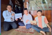 BANTUAN - Inilah penyerahan bantuan secara simbolis oleh Staf UPZ Bank Kalsel kepada Darsani Anang. (Foto Humasbankkalsel)