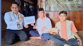 BANTUAN - Inilah penyerahan bantuan secara simbolis oleh Staf UPZ Bank Kalsel kepada Darsani Anang. (Foto Humasbankkalsel)