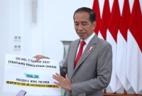 
Presiden Jokowi membawa dua kertas besar bertuliskan Pasal 299 dan 281 UU Pemilu saat menjelaskan aturan presiden boleh kampanye, Jumat (26/1). [Biro Pers Sekretariat Presiden]