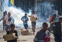 Massa yang terlibat rusuh menjarah pertokoan di Port Moresby, Papua Nugini. [AFP/Andrew Kutan]