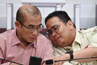 Ketua KPU Hasyim Asy'ari (kiri) berbincang dengan Ketua Bawaslu Rahmat Bagja (kanan) di sela konferensi pers terkait perkembangan rekapitulasi suara Pemilu 2024 di Kantor KPU, Jakarta, Kamis (15/2/2024). KPU saat ini telah menyerap data dokumen penghitungan suara atau C1 melalui Sistem Informasi Rekapitulasi (Sirekap) dari berbagai TPS sebanyak 358.775 dari 823.236 dokumen atau setara dengan 43,58 persen. [ANTARA FOTO/Aditya Pradana P]