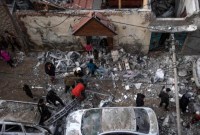Warga Palestina menyaksikan kehancuran pasca serangan udara Israel di Rafah, Jalur Gaza, Jumat (9/2/2024). [AP Photo/Fatima Shbair]