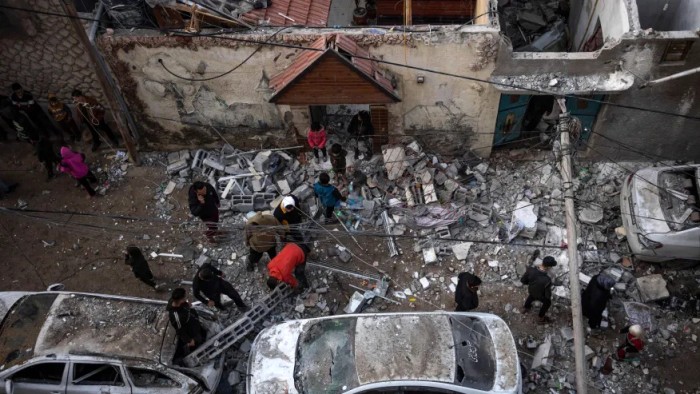 Warga Palestina menyaksikan kehancuran pasca serangan udara Israel di Rafah, Jalur Gaza, Jumat (9/2/2024). [AP Photo/Fatima Shbair]