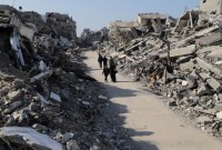 Warga Gaza berjalan melewati kehancuran di kamp pengungsi Jabalya di Gaza, Kamis (29/2/2024) lalu. [AP/Mahmoud Essa]