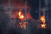 Asap dan api terlihat di sekitar saluran tegangan tinggi di lokasi serangan rudal Rusia, di tengah serangan Rusia ke Ukraina, di luar Kharkiv, Ukraina, Jumat (29/3/2024). [REUTERS/Sofiia Gatilova]