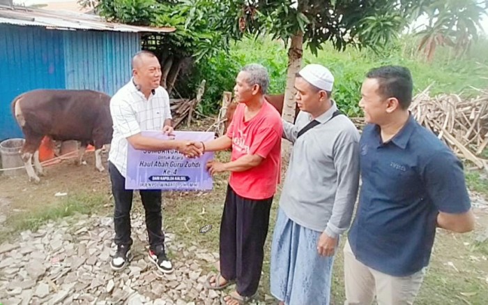 Kasubdit Sosbud Dit Intelkam Polda Kalsel, Kompol Zaenuri SH MM, meyerhkan bantuan seekor sapi dari kapolda, Selasa (5/3/2024). (SuarIndonesia/Ist)