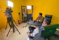 Kepala BPBD Kalsel Raden Suria Fadliansyah (baju lengan panjang) sedang melakukan uji coba alat media podcast , di Ruang Komunikasi Infornasi dan Edukasi (KIE) Kantor BPBD Kalsel, Rabu (20/3/2024). (SuarIndonesia/Ist)